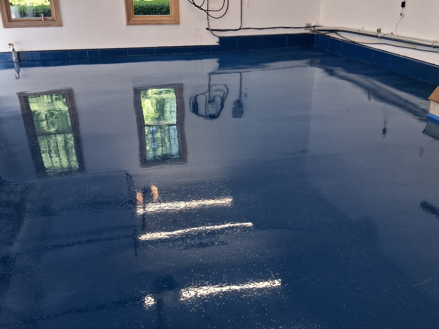 A reflective resin floor beside windows